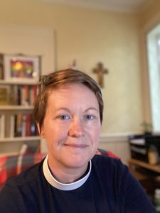 Rev. Cara Rockhill in her office, wearing a black shirt and white clerical collar